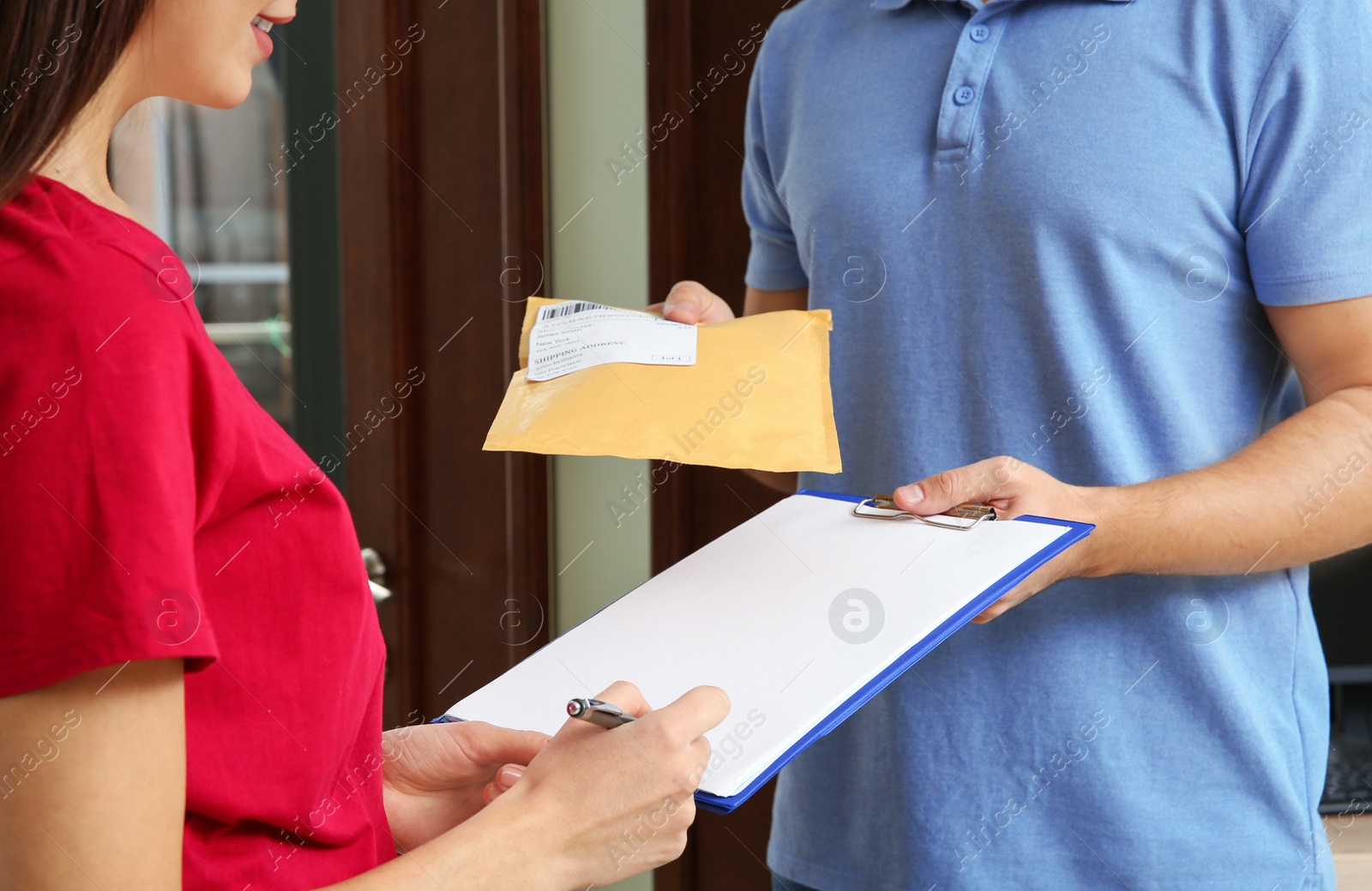 Photo of Woman receiving padded envelope from delivery service courier indoors, closeup