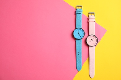 Flat lay composition with stylish wrist watches and space for text on color background. Fashion accessory