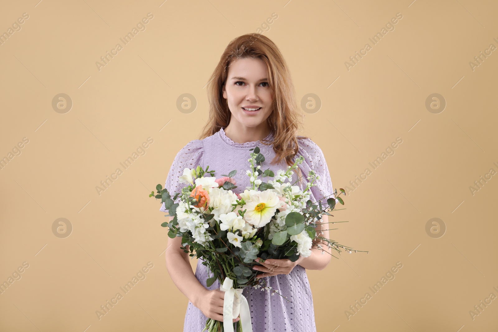 Photo of Beautiful woman with bouquet of flowers on beige background