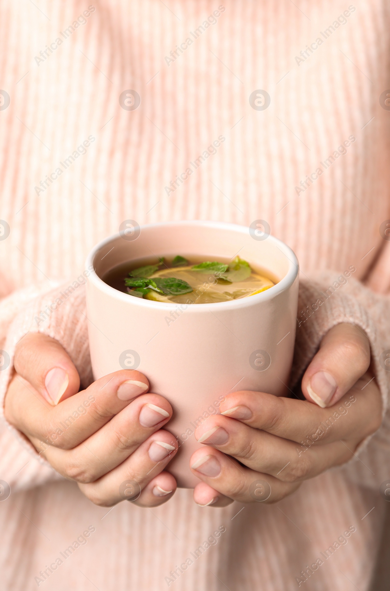 Photo of Woman holding cup with hot tea, closeup