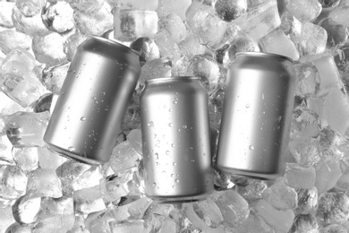 Tin cans on ice cubes, flat lay