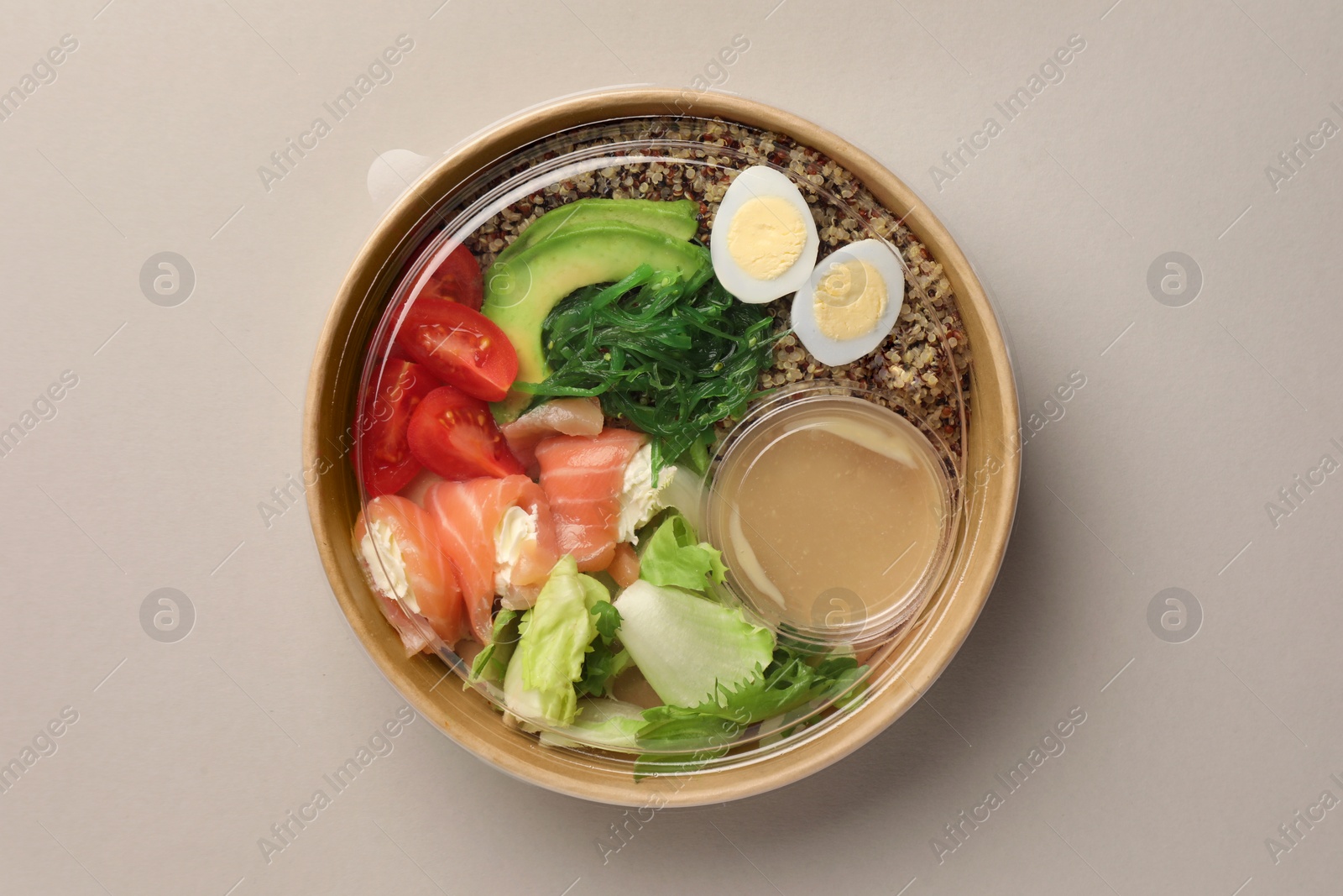 Photo of Tasty food in container on light background, top view