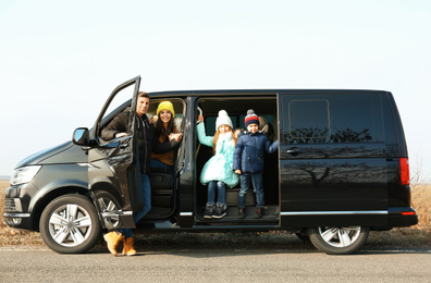 Photo of Happy family with little children in modern car on road