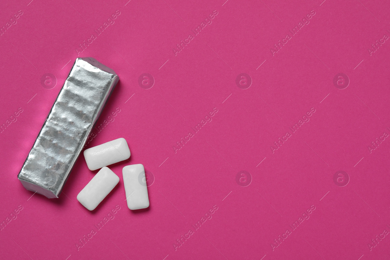 Photo of Pack with tasty chewing gums on pink background, flat lay. Space for text