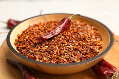 Bowl with crushed chili pepper and pods, closeup