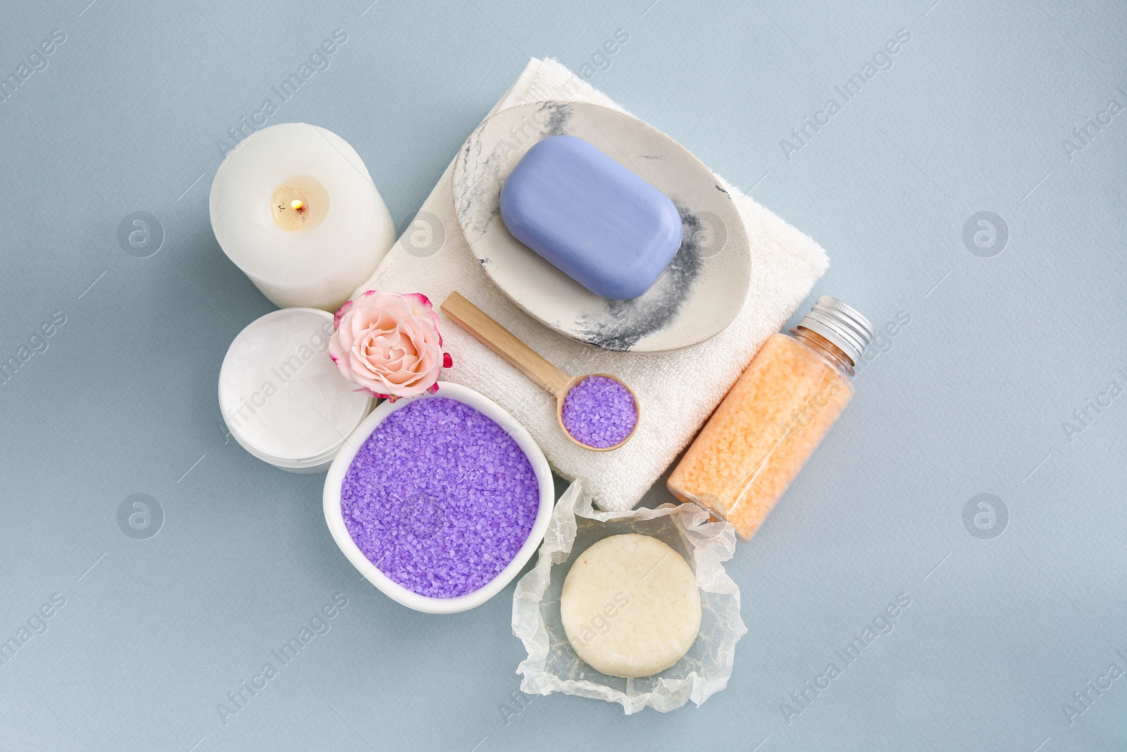 Photo of Sea salt, candle and soap bar on light grey background, flat lay