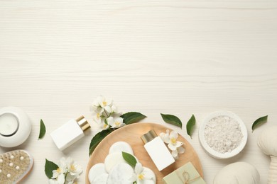 Photo of Flat lay composition with spa stones and beautiful jasmine flowers on white wooden table, space for text