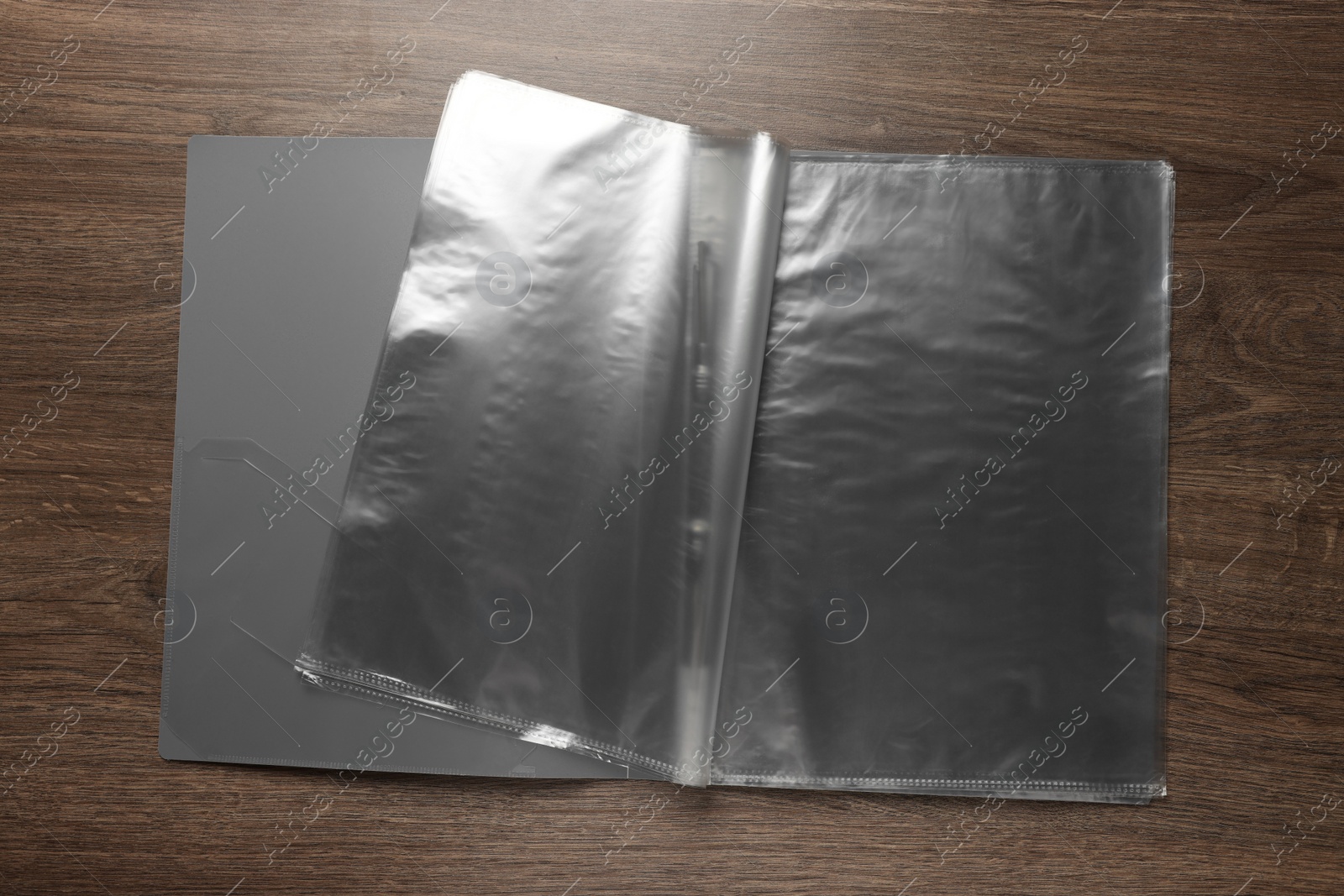 Photo of File folder with punched pockets on wooden table, top view