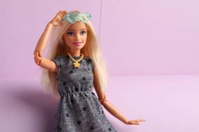 Photo of Mykolaiv, Ukraine - September 4, 2023: Beautiful Barbie doll with stylish eyeglasses on lilac background, space for text