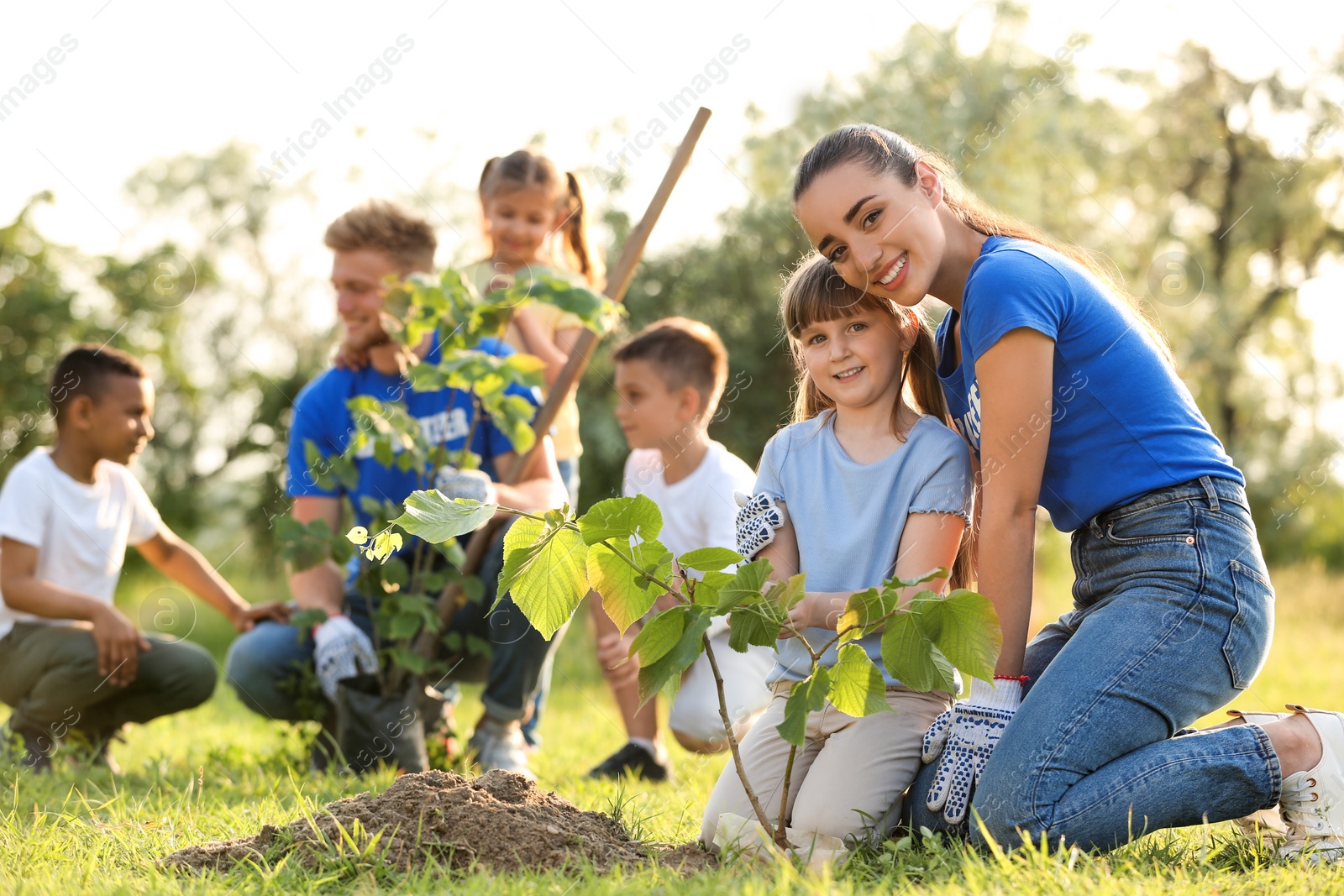 Photo of Kids planting trees with volunteers in park