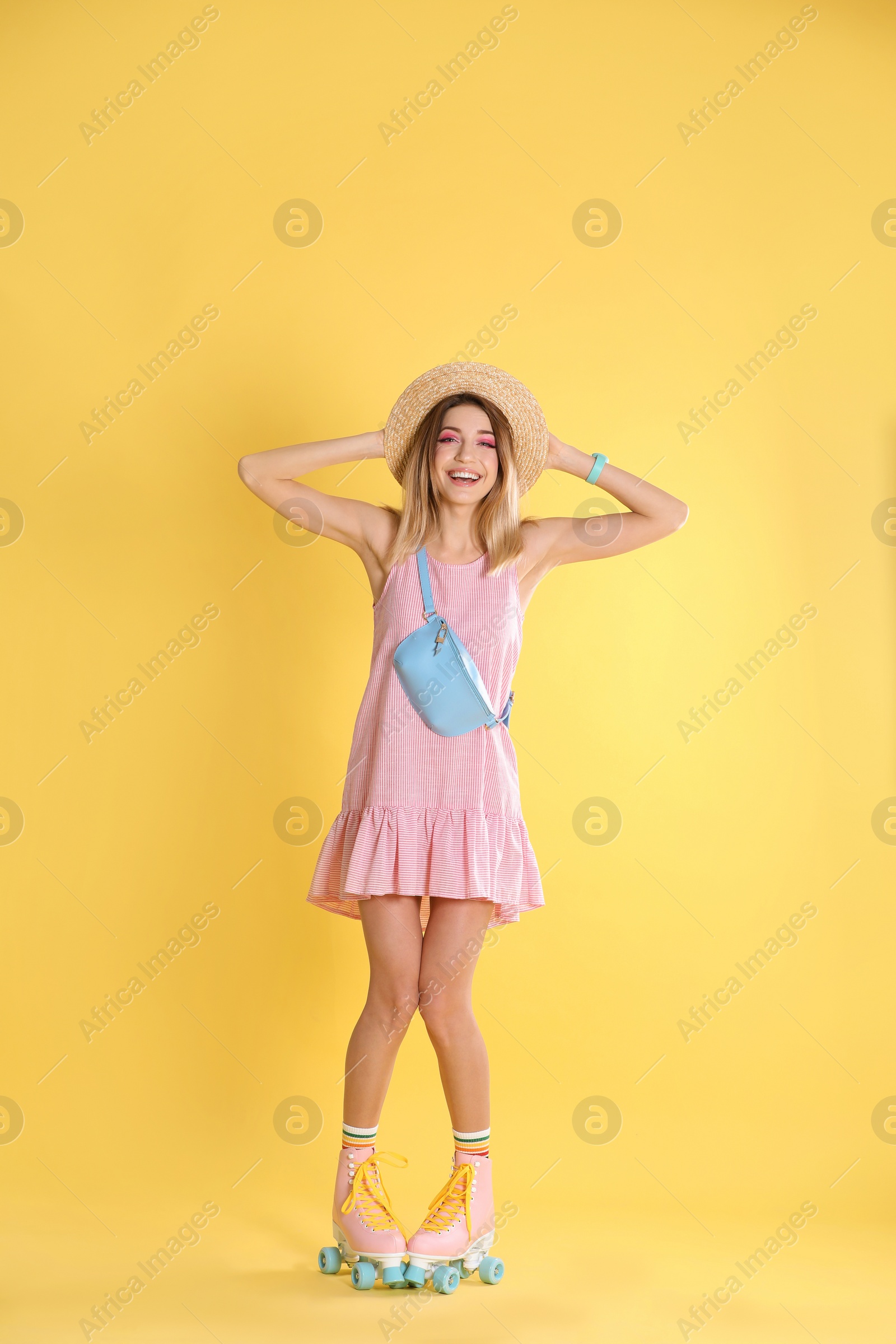 Photo of Young woman with retro roller skates on color background