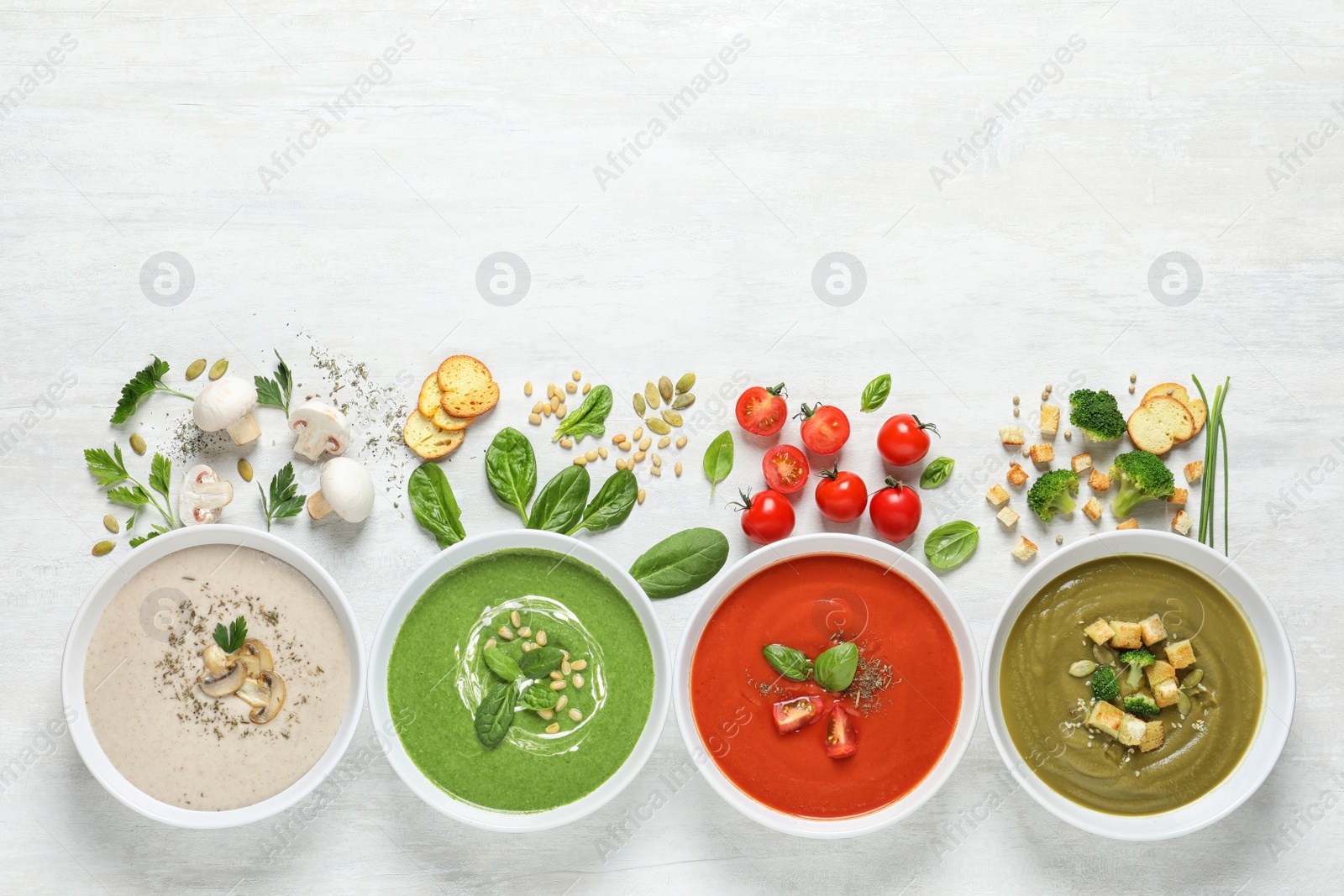 Photo of Flat lay composition with various soups, ingredients and space for text on white background. Healthy food