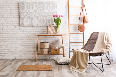 Photo of Stylish living room interior with cozy armchair near brick wall