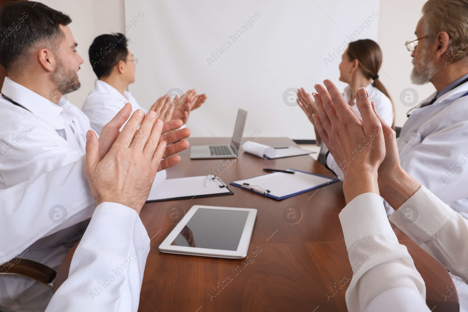 Photo of Team of doctors using video projector during conference indoors