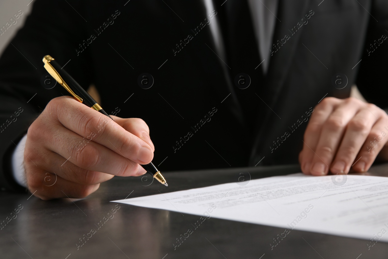 Photo of Male notary signing document at table, closeup