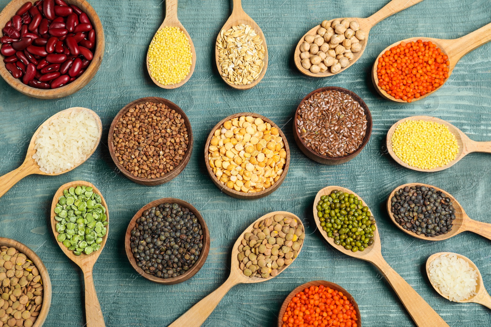 Photo of Flat lay composition with different types of legumes and cereals on blue wooden table. Organic grains