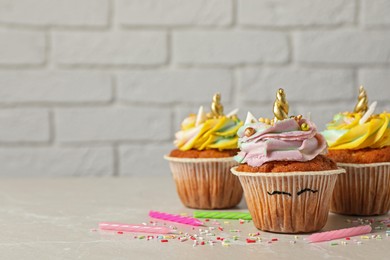 Photo of Cute sweet unicorn cupcakes on beige table, space for text