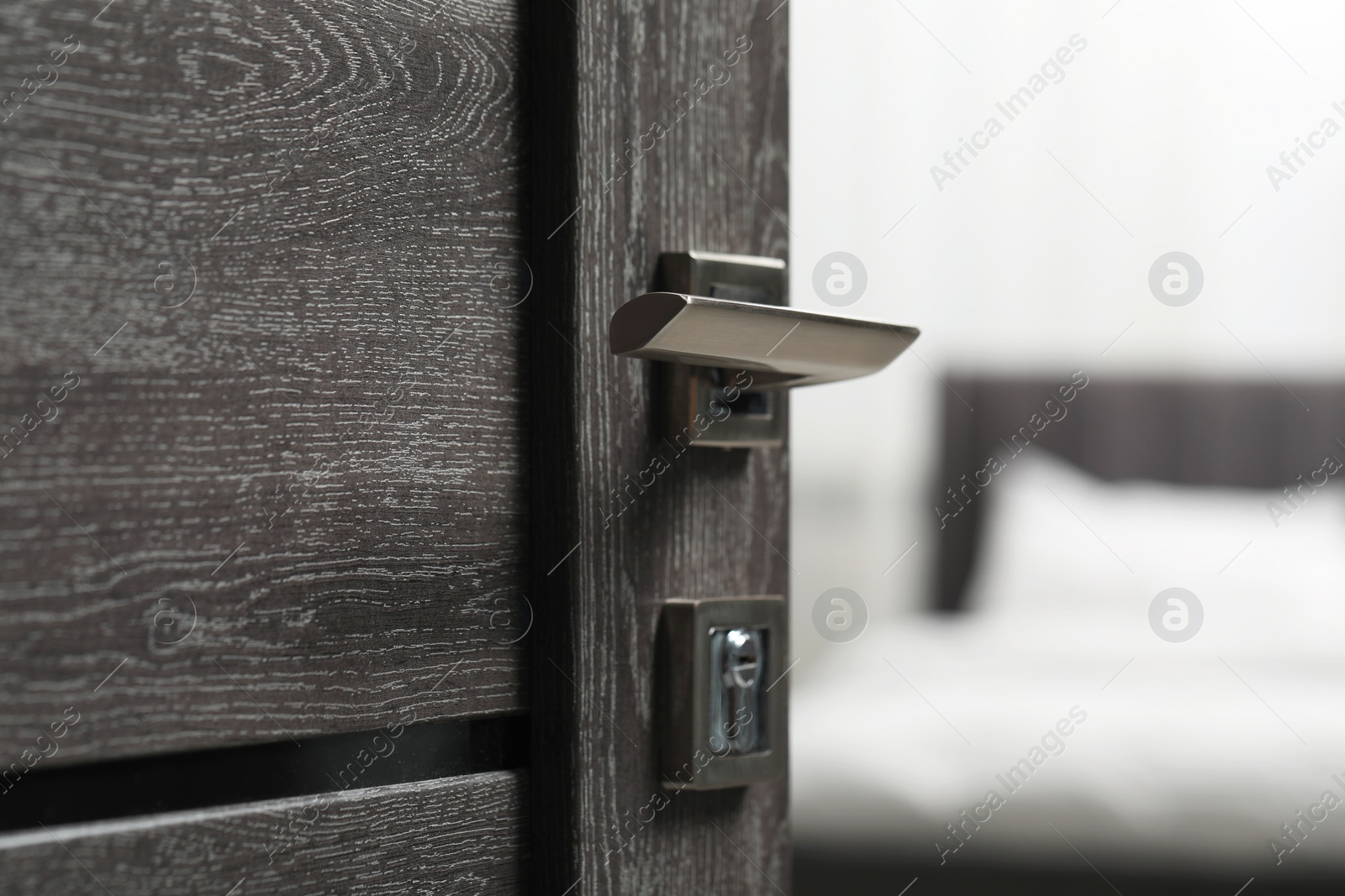 Photo of Open wooden door with metal handle, closeup