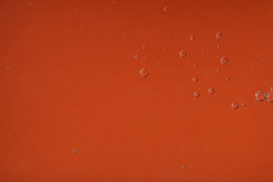 Photo of Pure transparent cosmetic gel on orange background, closeup