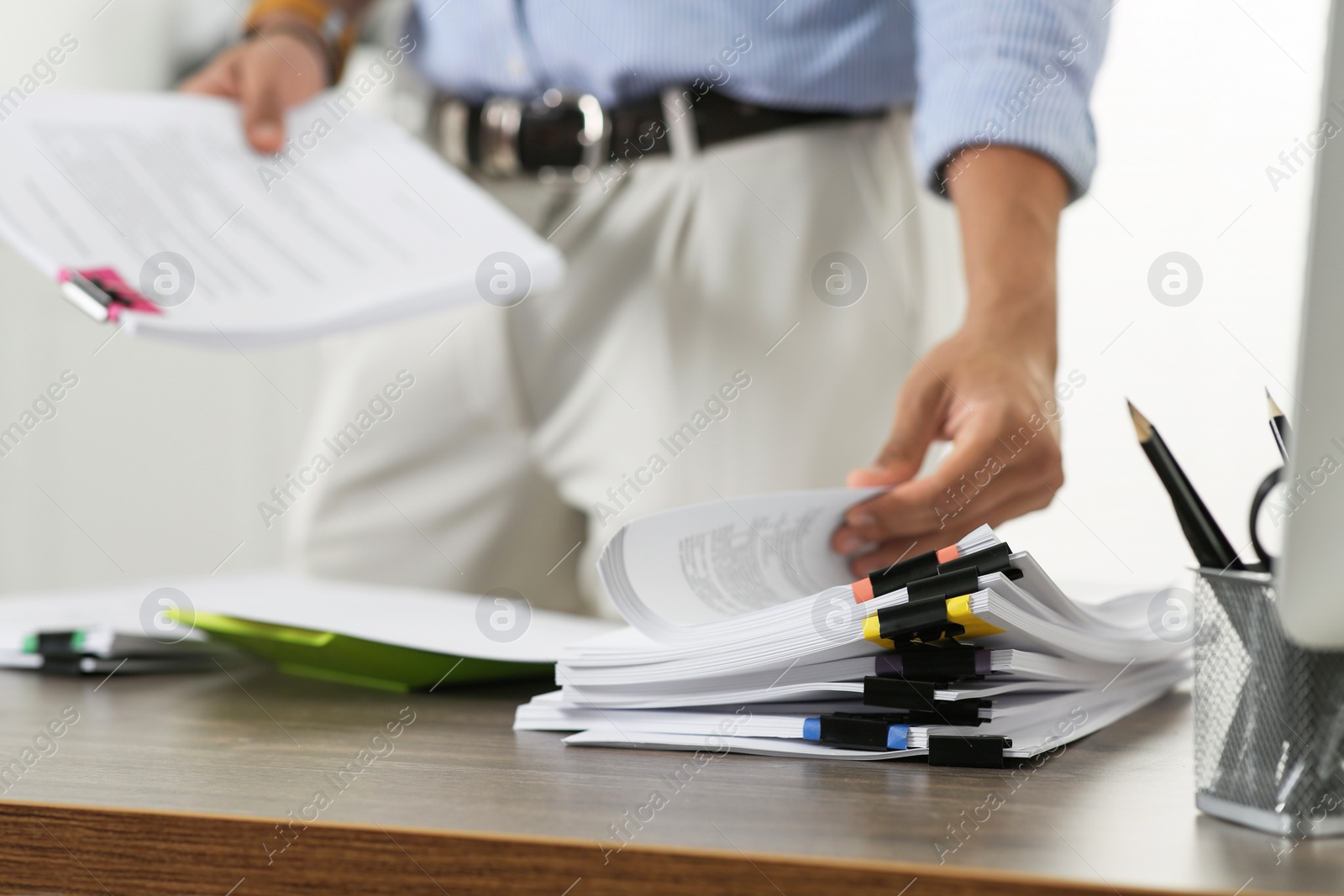 Photo of Man working with documents at wooden table in office, closeup