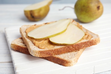 Photo of Slice of bread with peanut butter and pear on white board