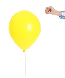 Photo of Woman piercing yellow balloon on white background, closeup