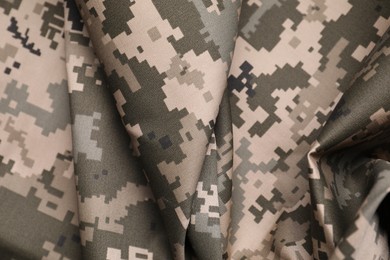 Texture of crumpled camouflage fabric as background, top view