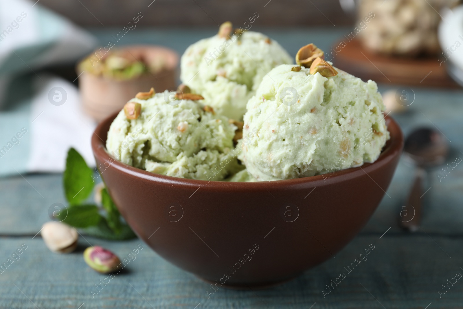 Photo of Delicious pistachio ice cream in bowl on table, closeup