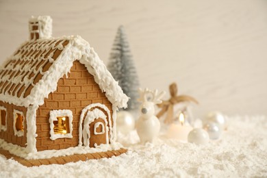 Photo of Beautiful gingerbread house decorated with icing on snow, space for text