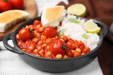 Photo of Delicious chickpea curry with rice on white wooden table, closeup