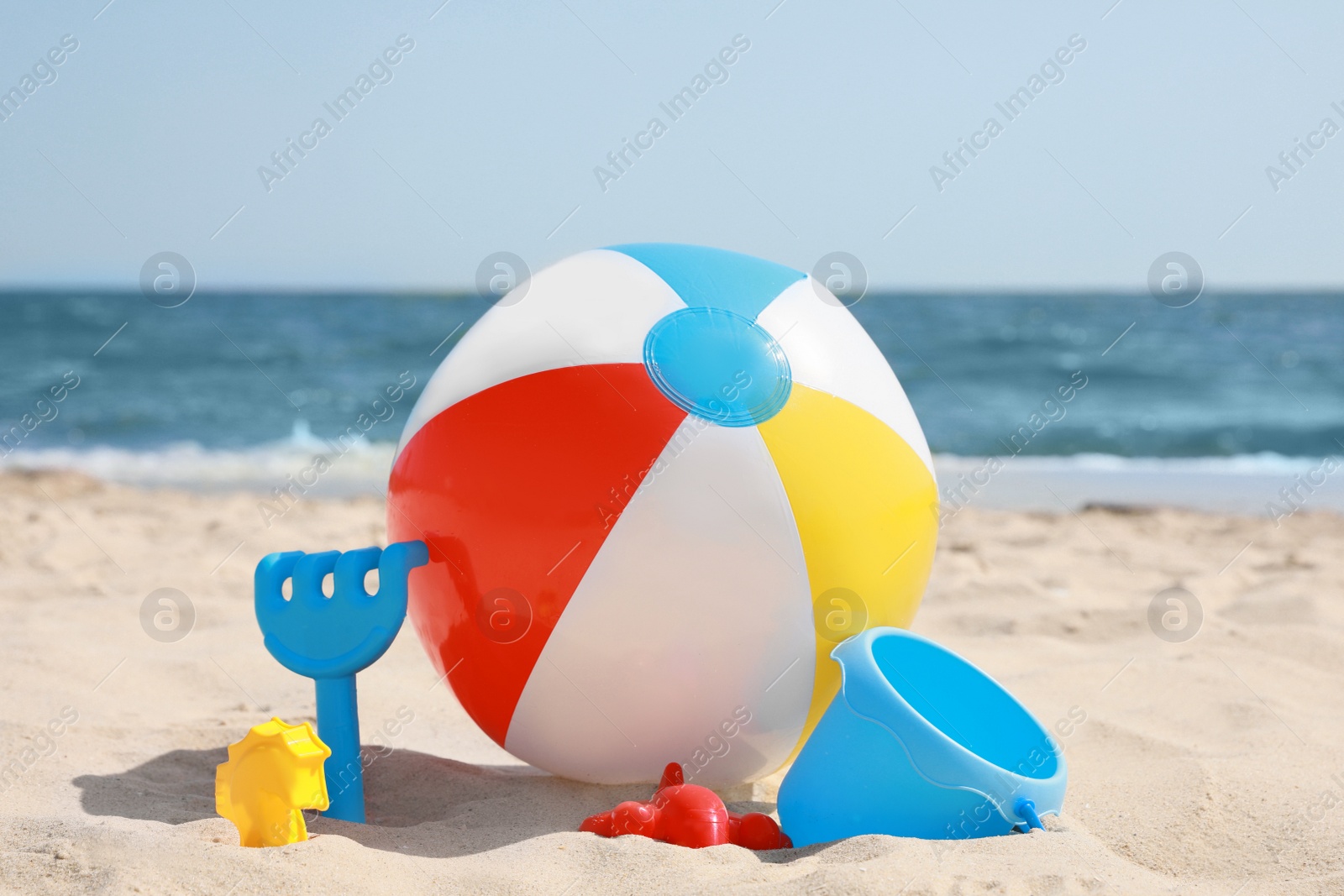 Photo of Many different sand toys and beach ball near sea