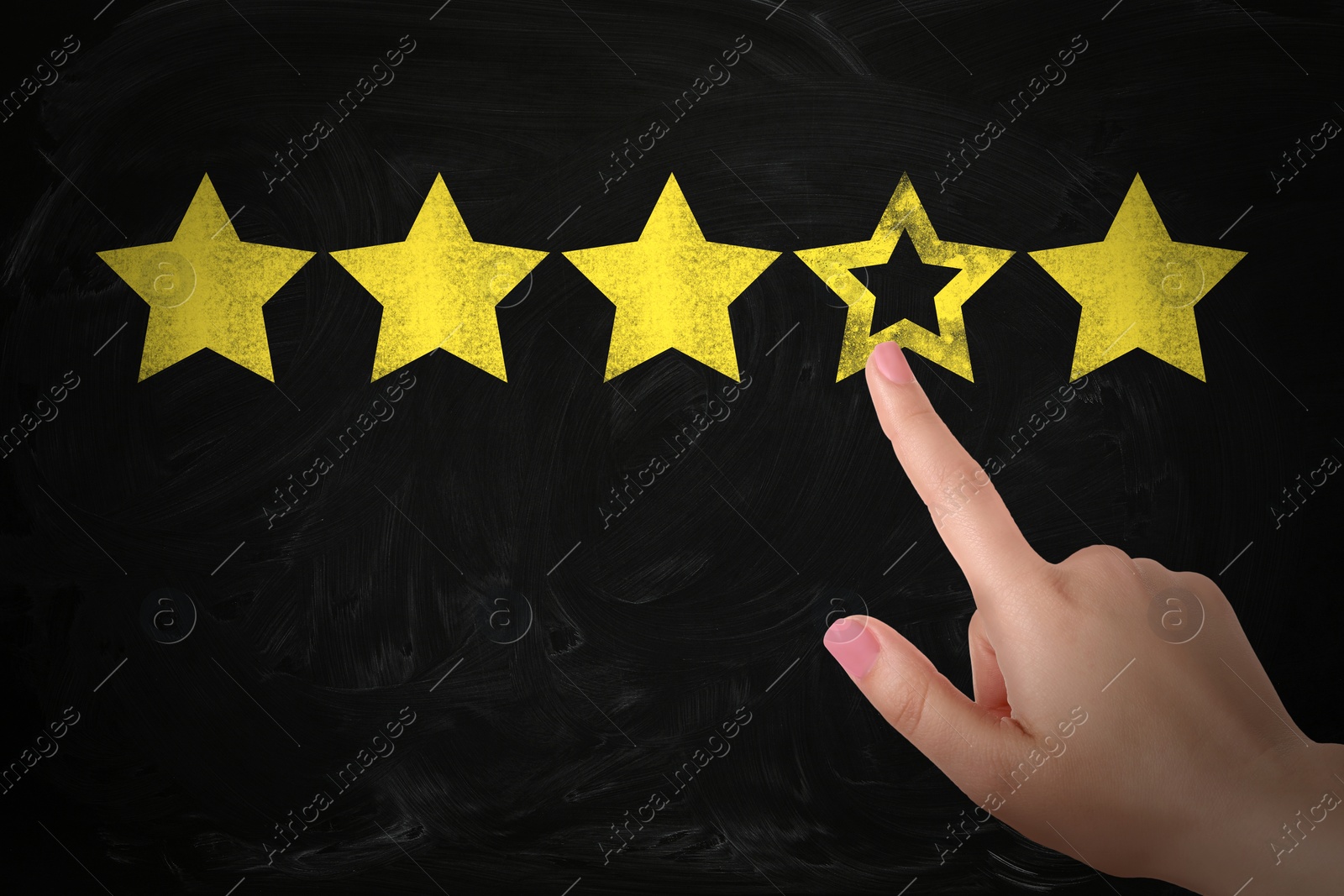 Image of Quality evaluation. Woman touching golden star on black chalkboard, closeup