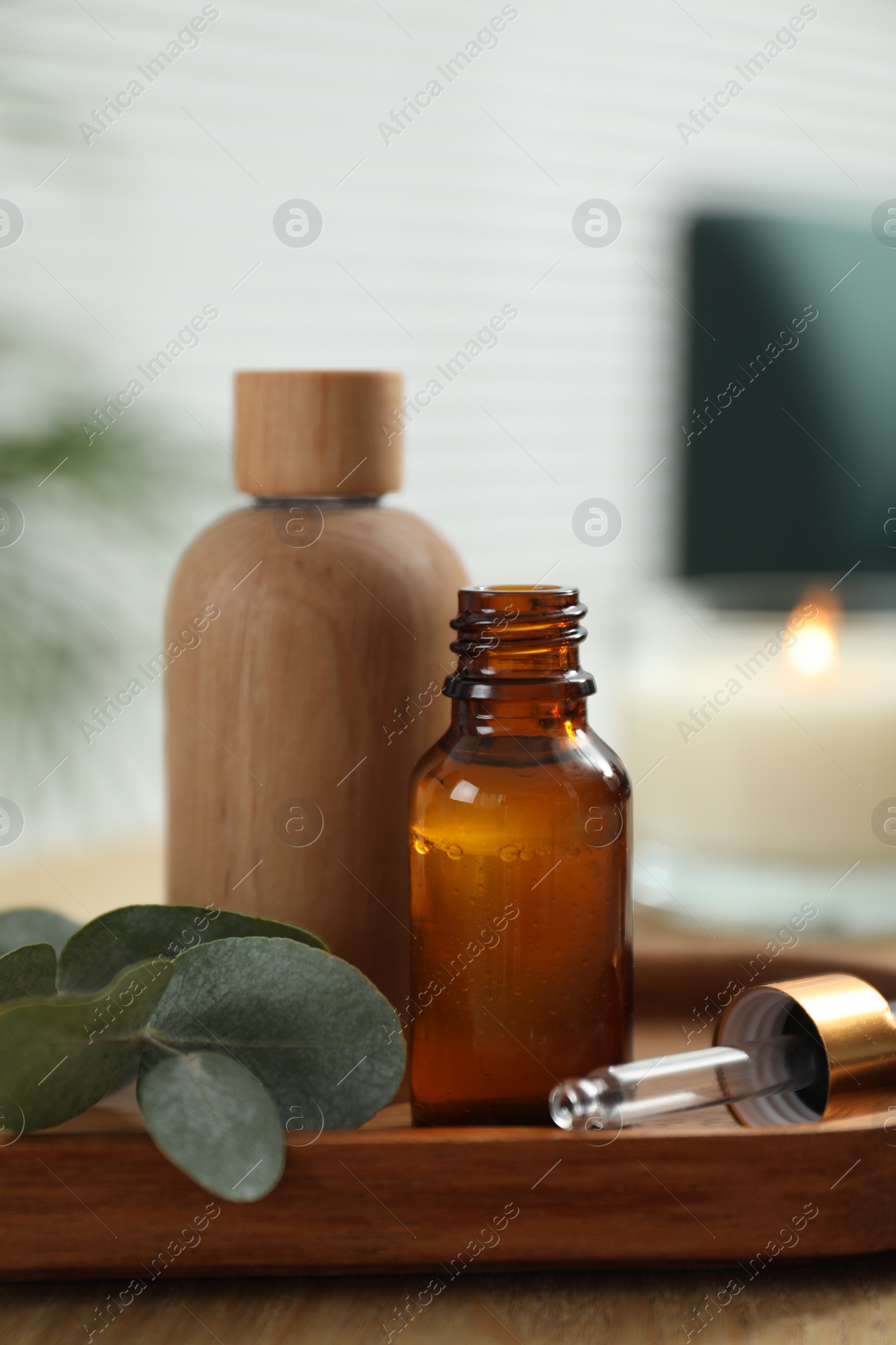 Photo of Aromatherapy. Bottles of essential oil and eucalyptus leaves on wooden table