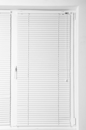 Photo of Modern window with closed stylish white blinds