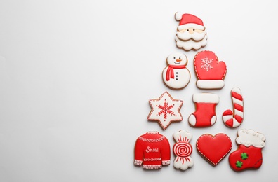 Photo of Christmas tree shape made of delicious gingerbread cookies on white background, flat lay. Space for text