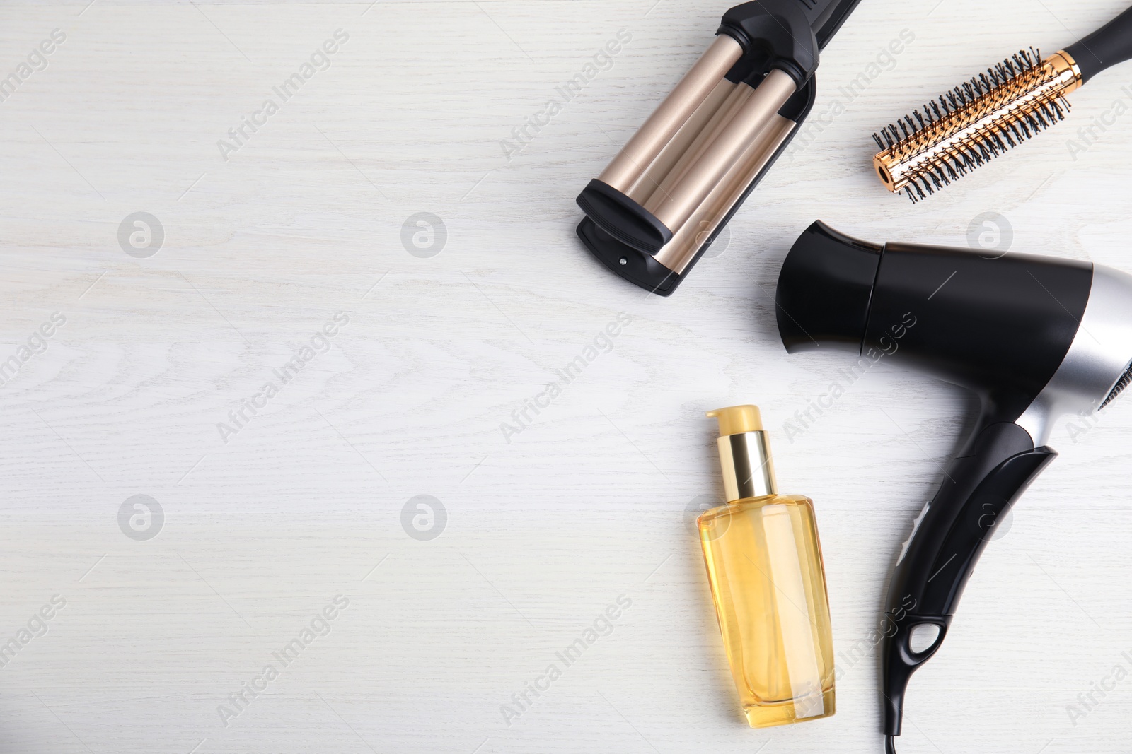 Photo of Flat lay composition with hairdressing equipment on white wooden background. Space for text