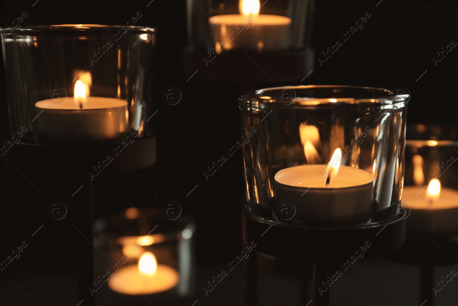 Photo of Burning candles on dark background. Funeral symbol