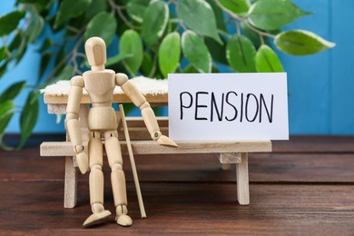 Photo of Card with word Pension and wooden human figure on table. Retirement concept