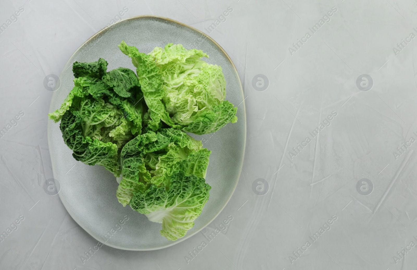 Photo of Fresh ripe Chinese cabbages on light grey table, top view. Space for text