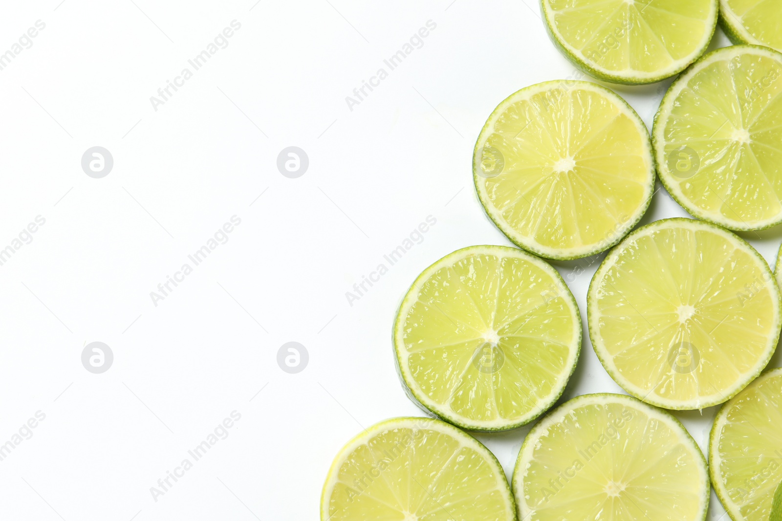 Photo of Fresh juicy lime slices on white background, flat lay. Space for text