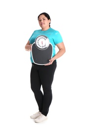 Overweight woman in sportswear with scales on white background