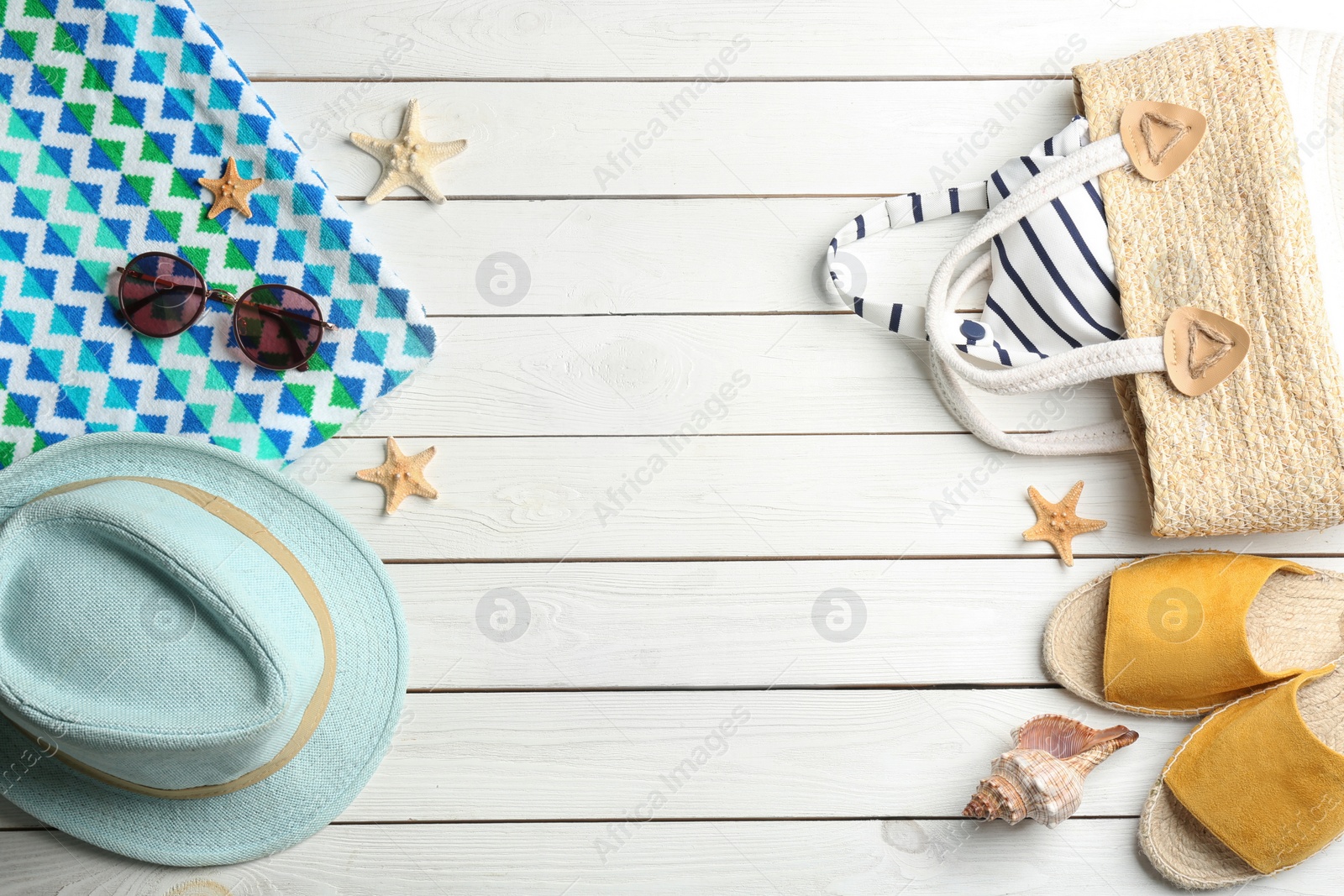 Photo of Beach accessories on white wooden table, flat lay. Space for text