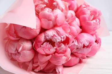 Photo of Bouquet of beautiful pink peonies on white wooden table, closeup