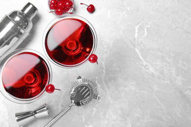 Photo of Glasses of fresh cocktail with cherries on marble table, flat lay. Space for text