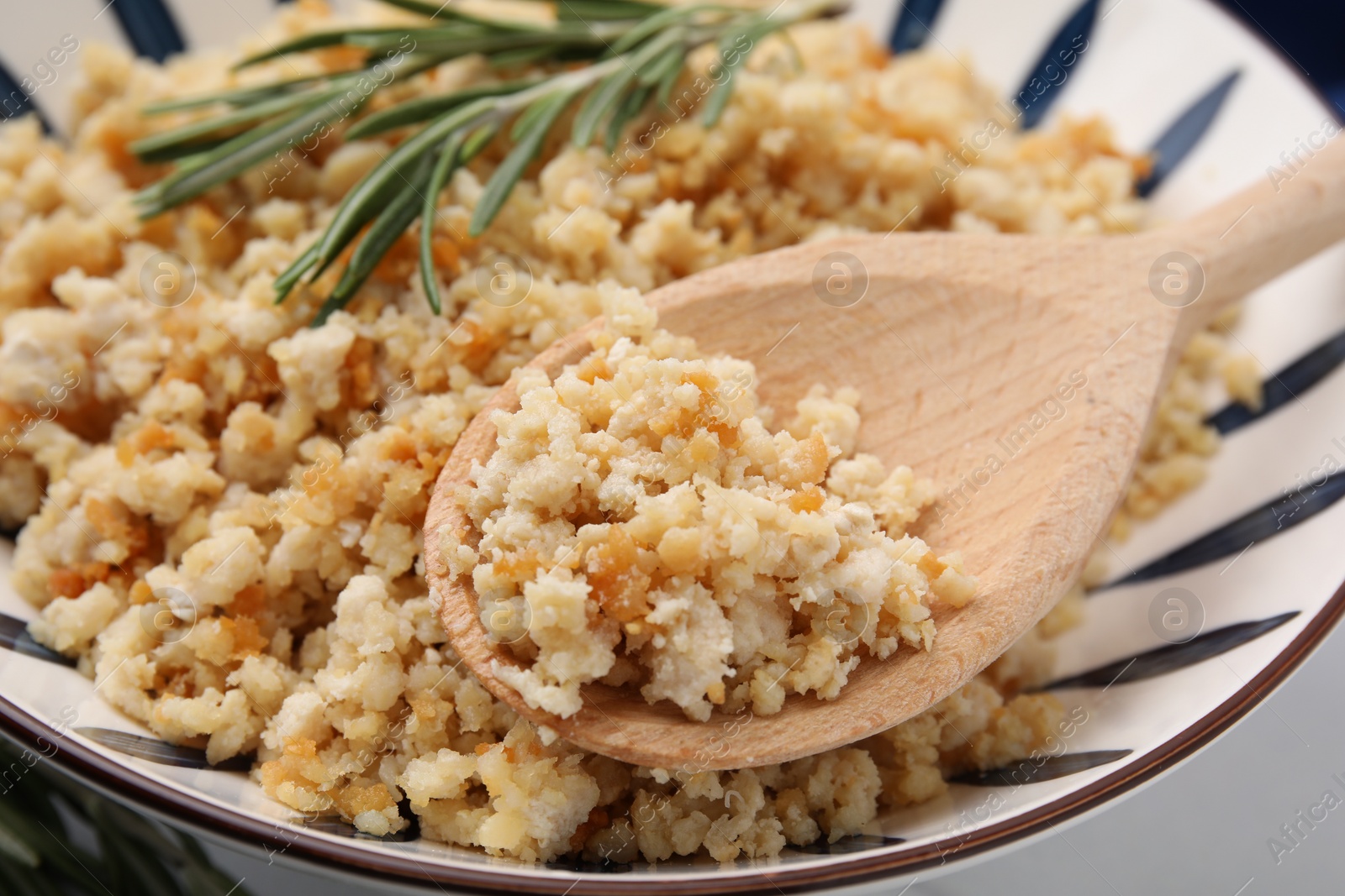 Photo of Holding spoon with fried ground meat over bowl, closeup