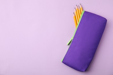 Photo of Many sharp pencils in pencil case on pink background, top view. Space for text