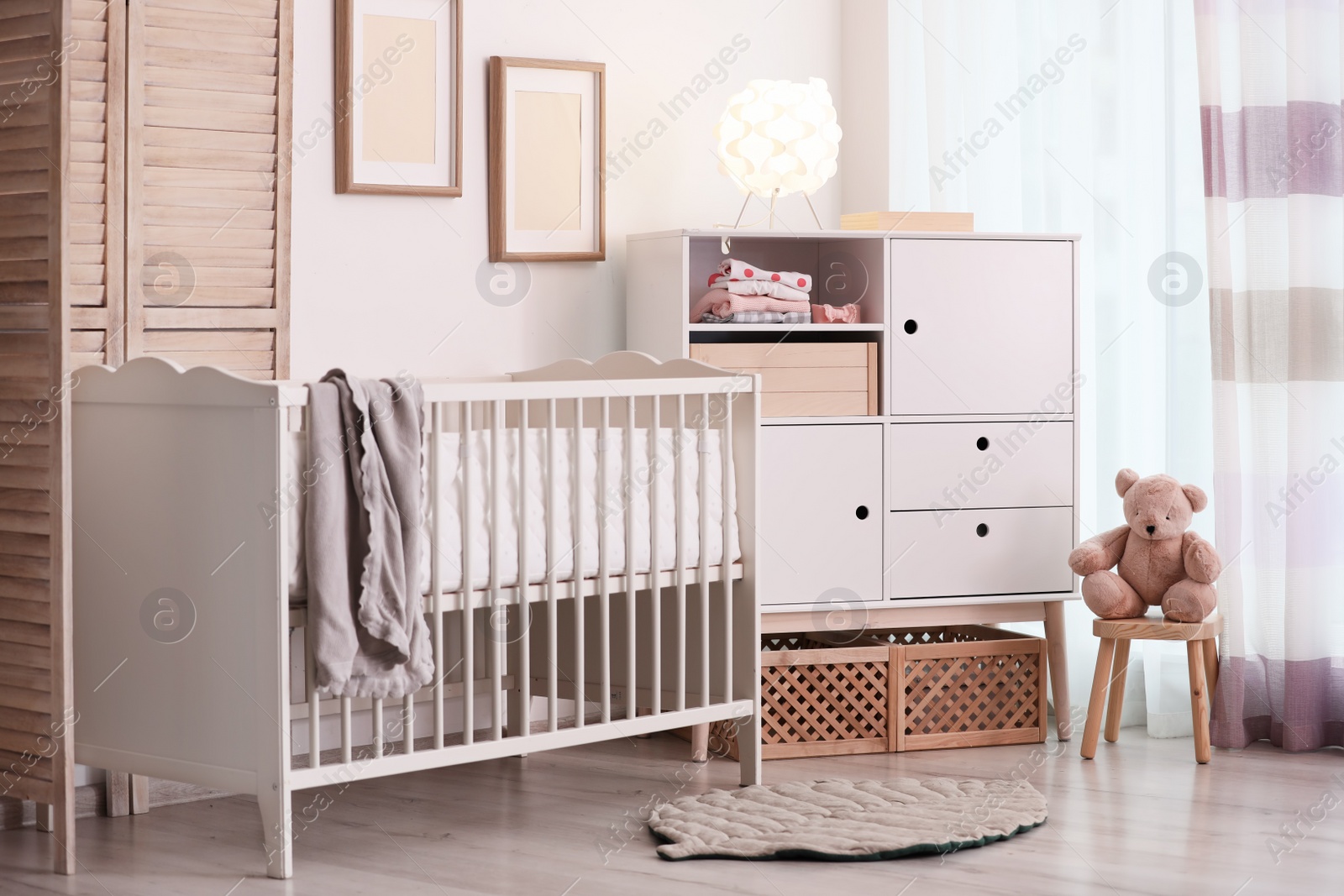 Photo of Modern room interior with crib and wooden crates under cupboard. Eco style