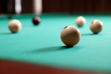 Many billiard balls on green table indoors, closeup