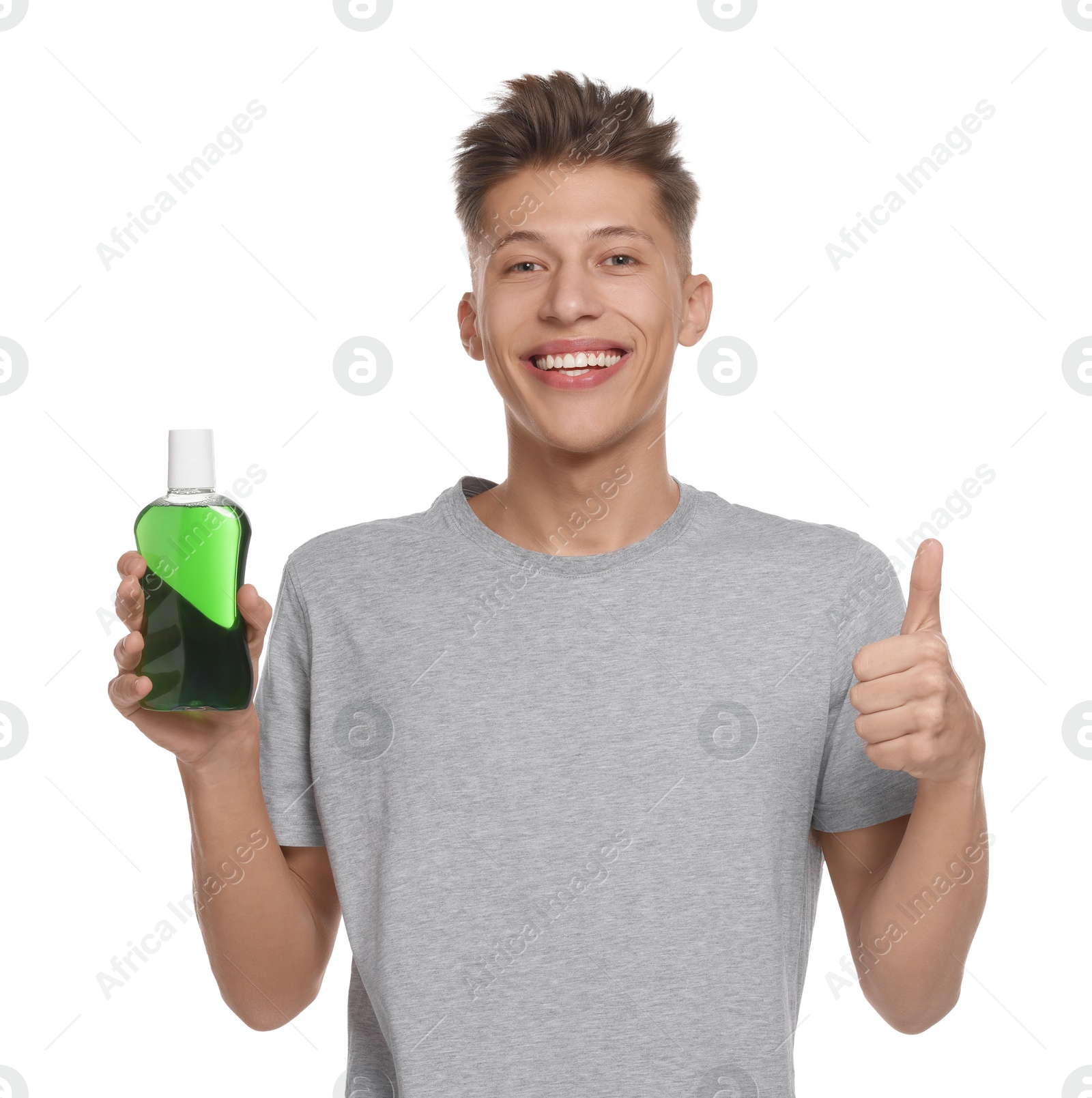 Photo of Young man with mouthwash showing thumbs up on white background