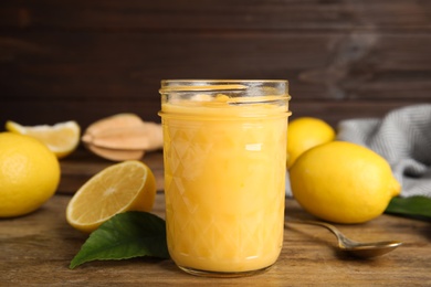 Delicious lemon curd and fresh fruits on wooden table